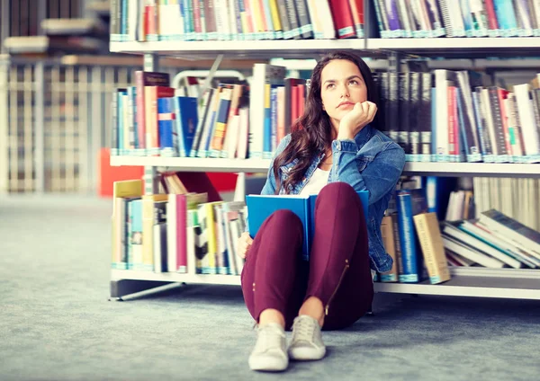 Estudiante de secundaria chica leyendo libro en la biblioteca — Foto de Stock