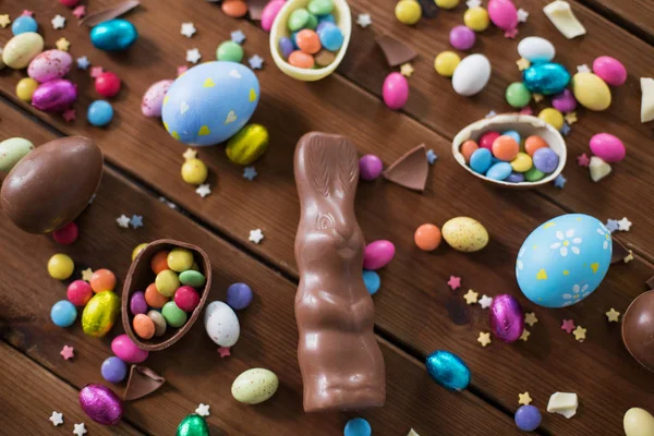 Ovos de chocolate, coelho de Páscoa e doces em madeira — Fotografia de Stock