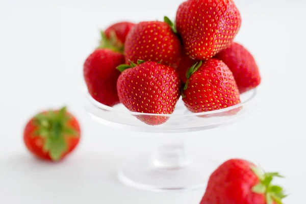 Fresas sobre soporte de vidrio sobre fondo blanco —  Fotos de Stock