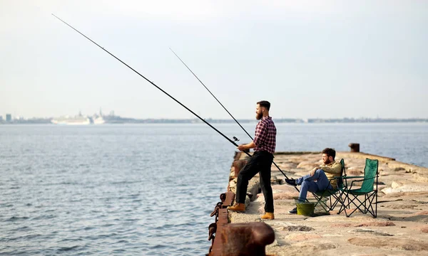 Gelukkig vrienden met hengels op pier — Stockfoto