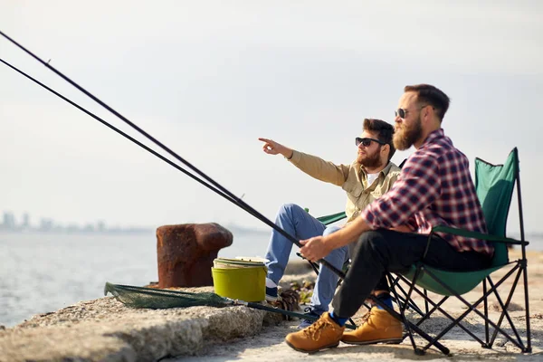 Amigos felizes com varas de pesca no cais — Fotografia de Stock