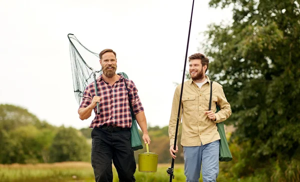 朋友与钓鱼竿和网走户外 — 图库照片