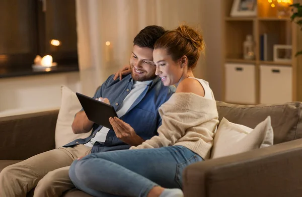 Feliz pareja usando la tableta PC en casa por la noche — Foto de Stock