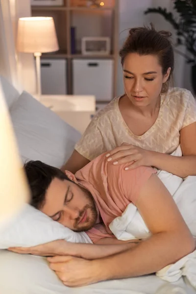 Žena se probudí spícího manžela v posteli doma — Stock fotografie