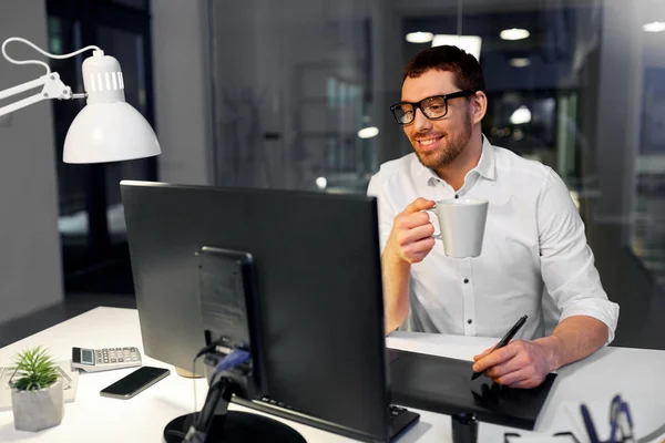 Designer com caneta comprimido beber café no escritório — Fotografia de Stock