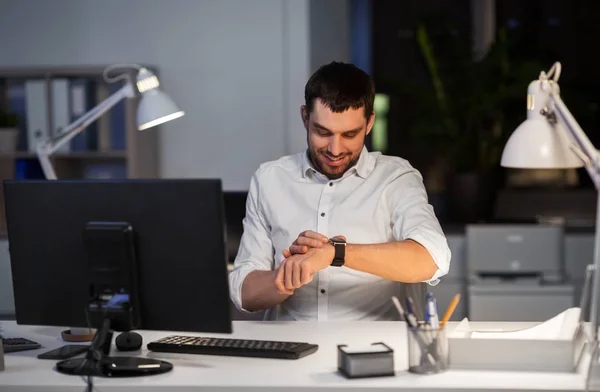 Happy businessman with smart watch at nigh office — Stock Photo, Image