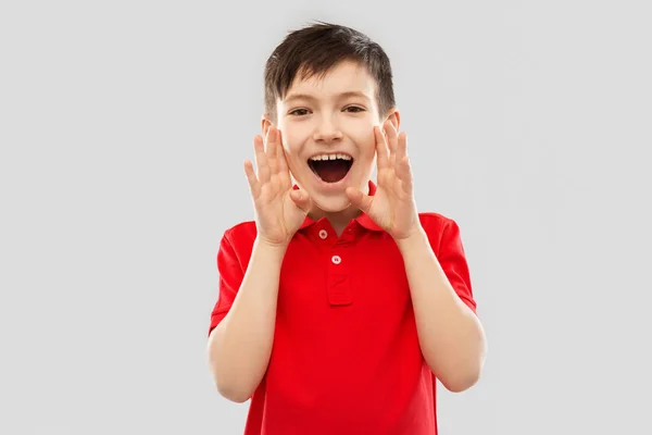 Pojke i röd polo t-shirt skriker eller ringer — Stockfoto