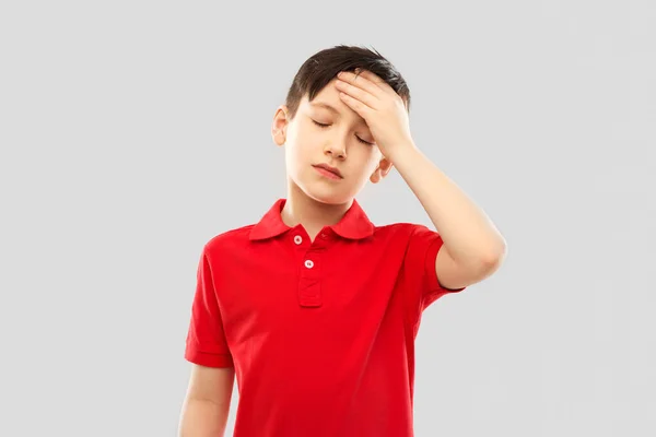 Băiat bolnav în tricou roșu care suferă de dureri de cap — Fotografie, imagine de stoc
