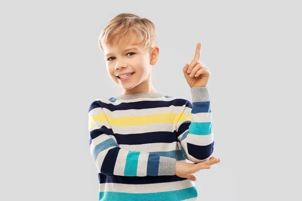 Niño pequeño en jersey a rayas apuntando con el dedo hacia arriba — Foto de Stock
