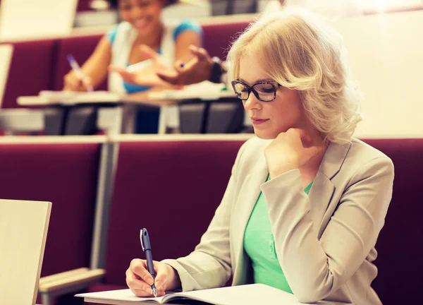 Dziewczyna Student, w piśmie do notebooka w sali wykładowej — Zdjęcie stockowe