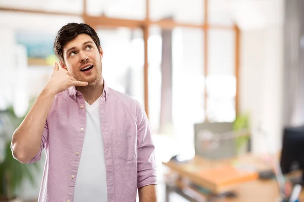 Muž se zobrazeným gestem telefonního hovoru nad kancelářskou místností — Stock fotografie