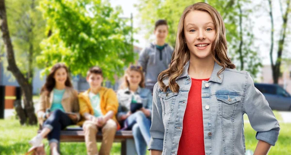 Улыбающаяся девочка-подросток в джинсовой куртке вместо друзей — стоковое фото