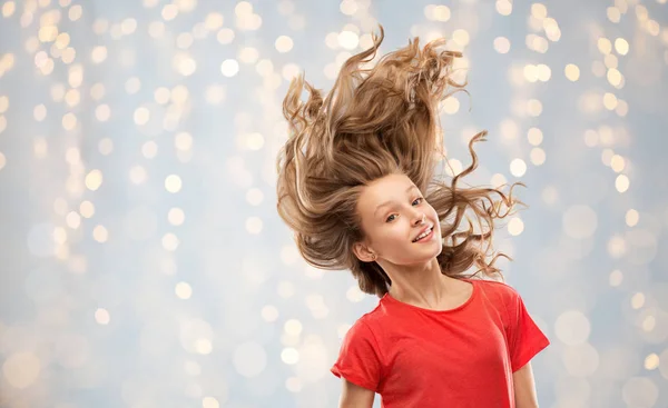 Adolescente souriante en rouge avec de longs cheveux ondulés — Photo