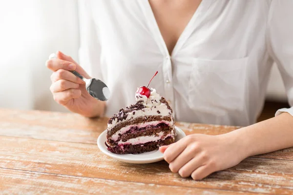 Mujer comiendo pedazo de pastel de capa con cereza — Foto de Stock