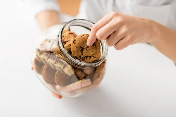 Close-up van de vrouw rekening havermout koekjes van jar — Stockfoto