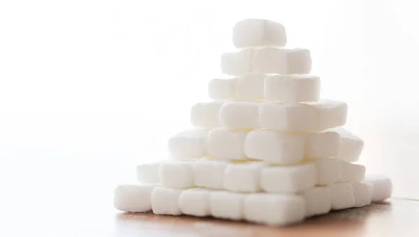 Закрытие пирамиды белого комочка сахара на столе — стоковое фото
