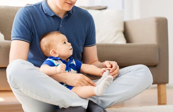 Ojciec z dzieckiem syna siedzi na podłodze w domu — Zdjęcie stockowe