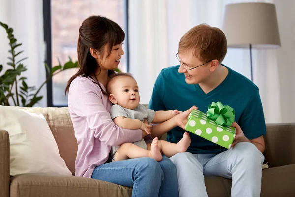 Mother with baby giving birthday present to father — Stock Photo, Image