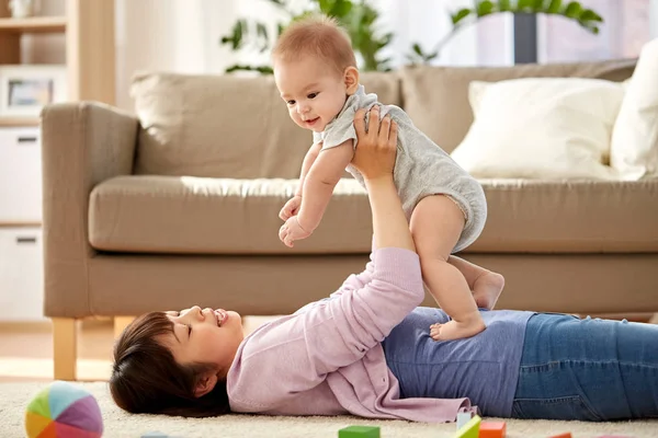 Mãe feliz brincando com o filhinho em casa — Fotografia de Stock