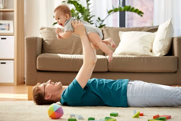 Счастливый отец с маленьким сыном, играющим дома — стоковое фото