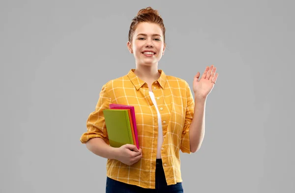 Εφηβικό μαθήτρια κορίτσι με τα βιβλία κουνώντας το χέρι — Φωτογραφία Αρχείου
