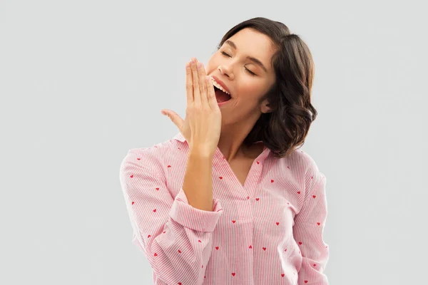 Glückliche junge schläfrige Frau im Pyjama gähnt — Stockfoto