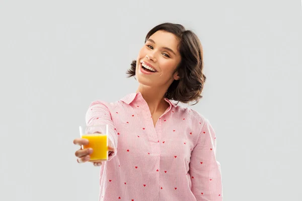 Glückliche junge Frau im Pyjama mit Orangensaft — Stockfoto