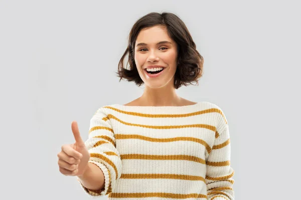 Sorrindo mulher no pulôver mostrando polegares para cima — Fotografia de Stock