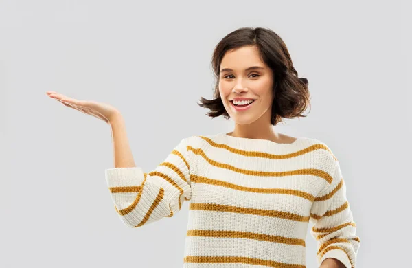 Lächelnde junge Frau mit leerer Handfläche — Stockfoto