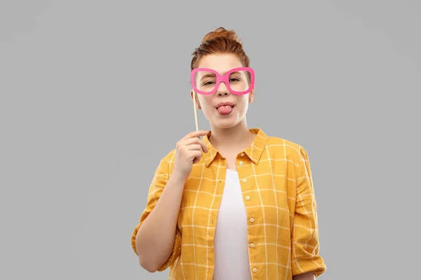 Улыбающаяся рыжая девочка-подросток в больших очках Стоковая Картинка