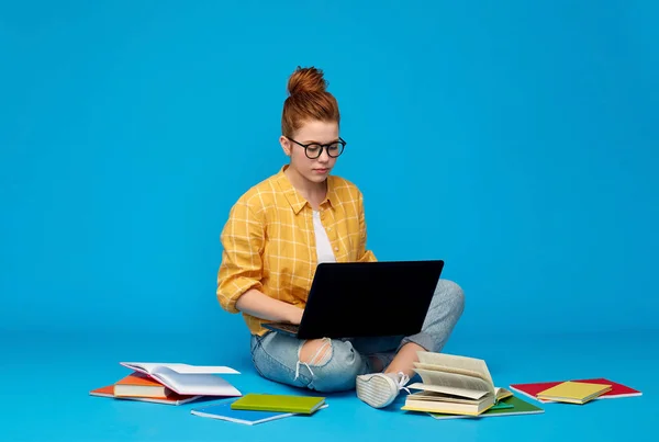 Kızıl saçlı genç öğrenci kız dizüstü bilgisayar ve kitap — Stok fotoğraf