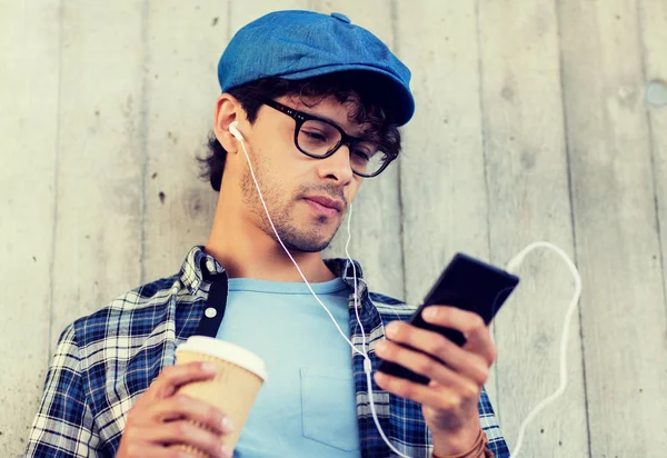 Hombre con auriculares y teléfono inteligente beber café —  Fotos de Stock