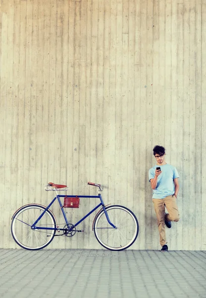 Homem com smartphone e bicicleta de engrenagem fixa na rua Fotos De Bancos De Imagens Sem Royalties