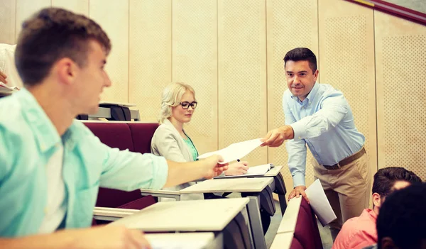 Profesor dando exámenes a los estudiantes en la conferencia — Foto de Stock