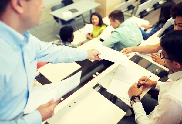 Profesor dando exámenes a los estudiantes en la sala de conferencias — Foto de Stock