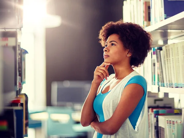 African student girl choosing book at library — Stock Photo, Image