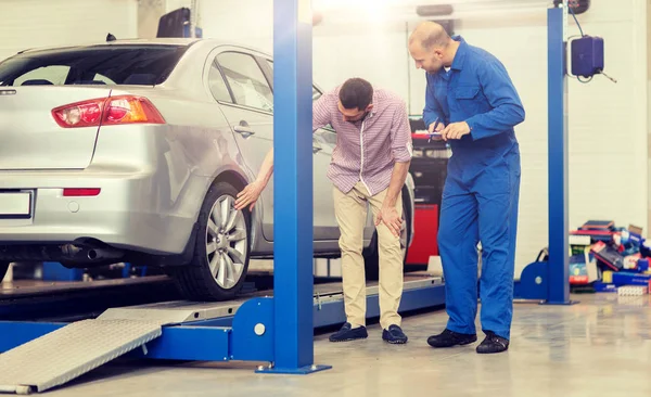 Meccanico con appunti e uomo in officina — Foto Stock