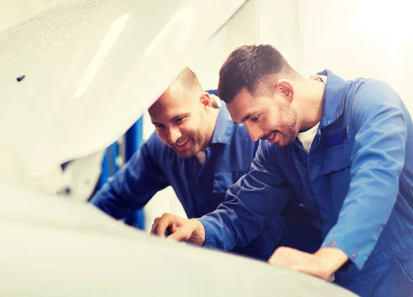 Mekaniker män med skiftnyckel reparera bilen på verkstad — Stockfoto