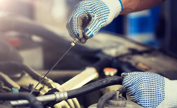 Mechanic with dipstick checking motor oil level Royalty Free Stock Images