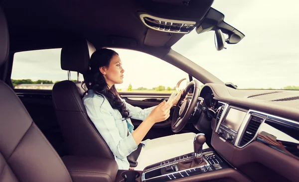 Glückliche Frau fährt Auto mit Smartphone lizenzfreie Stockfotos