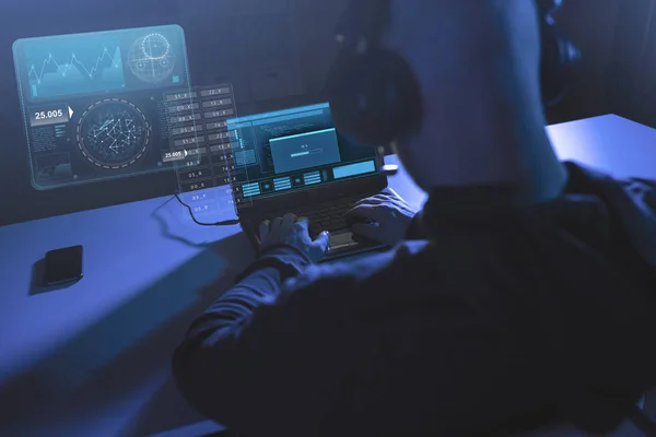 Hacker com barra de progresso no laptop no quarto escuro — Fotografia de Stock