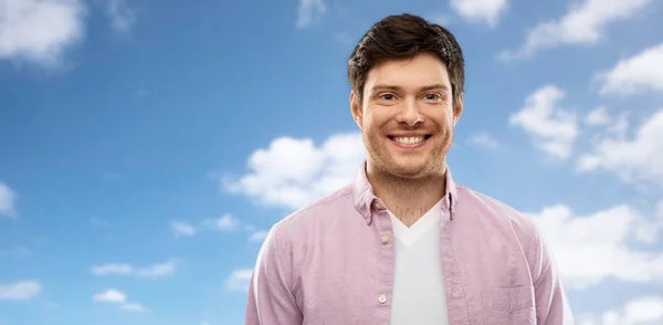 Sorridente homem sobre azul céu e nuvens fundo — Fotografia de Stock