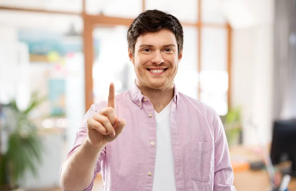 Jonge man toont een vinger over kantoor kamer — Stockfoto