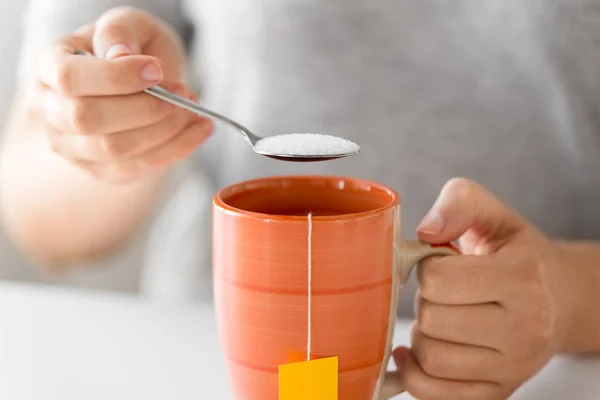 Крупним планом жінка додає цукор до чаю — стокове фото