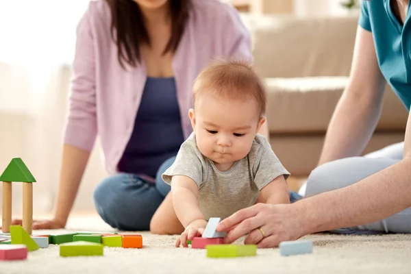 Glückliche Familie mit Baby, das zu Hause spielt — Stockfoto