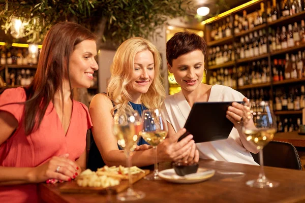 Mujeres con tableta PC en el bar de vinos o restaurante —  Fotos de Stock