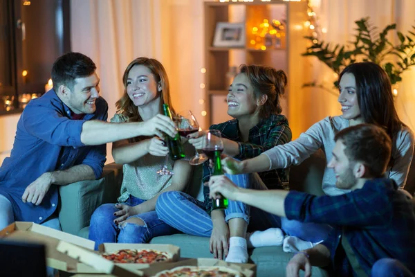 Amigos com bebidas e pizza assistindo tv em casa — Fotografia de Stock