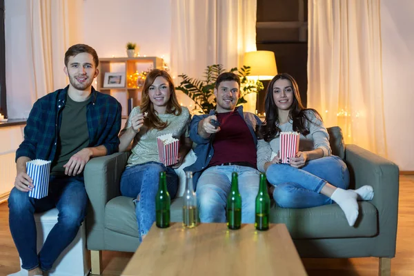 Přátelé s pivem a popcorn sledování televize doma — Stock fotografie