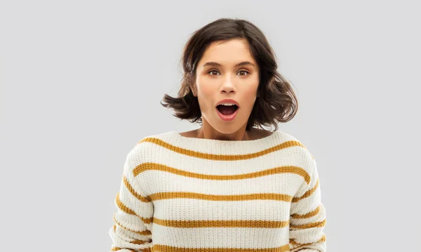 Zaskoczona młoda kobieta w pasiastej swetrze — Zdjęcie stockowe