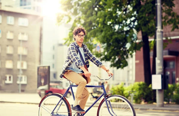 Mladý hipster muž s taškou na koni pevné kolo — Stock fotografie